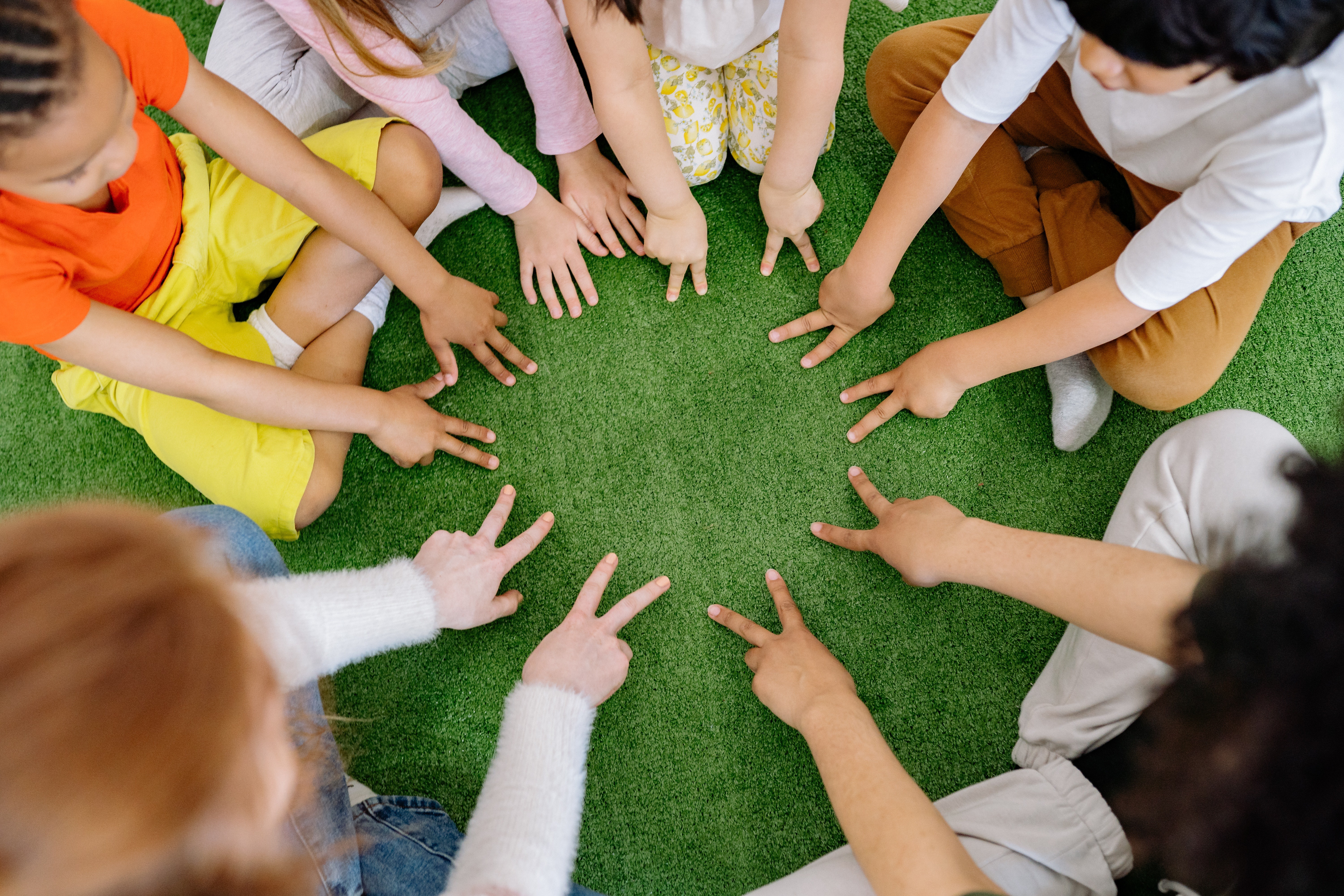 np_Top view of group of children sitting on the grass in circle_5lMxN4_standard_photo